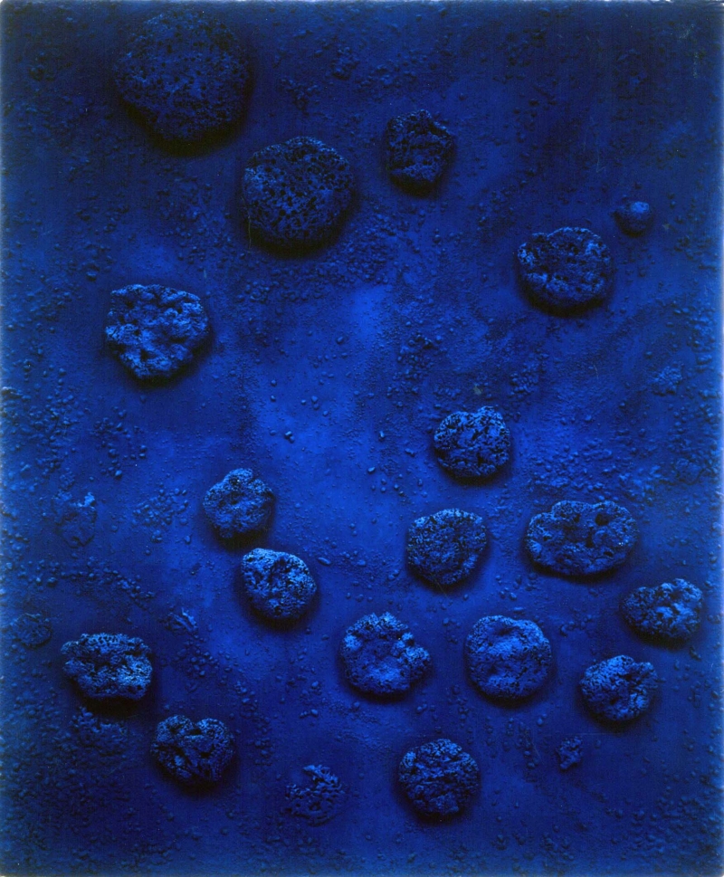 Blauer Hintergrund mit unregelm&auml;&szlig;igen, erdigen Formen in verschiedenen Gr&ouml;&szlig;en, die wie Steine oder Klumpen wirken.