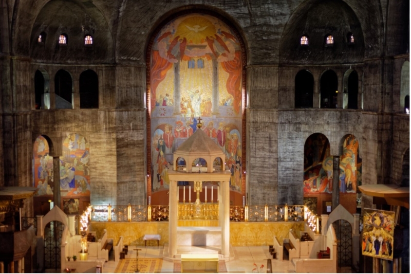 Interior of &Eacute;glise Saint-Esprit featuring a central altar, vibrant murals, and a high arched ceiling.