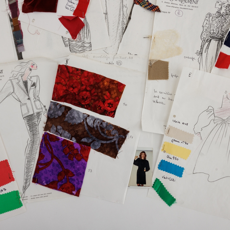 Stapel aus Modezeichnungen, Stoffmustern und Farbproben, darunter Skizzen von Yves Saint Laurent.