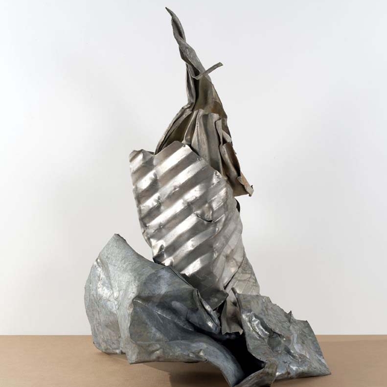 Abstract sculpture with crumpled metallic surfaces and layered forms, showcasing dynamic shapes and textures.