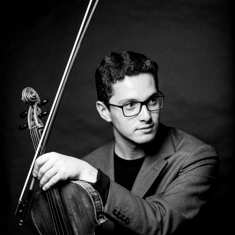 Der Musiker Hugo Max, sitzend mit eGeige und Bogen